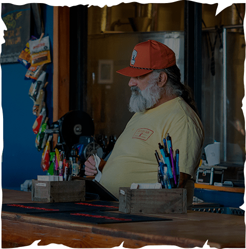 a man sitting at a table with pens and pencils