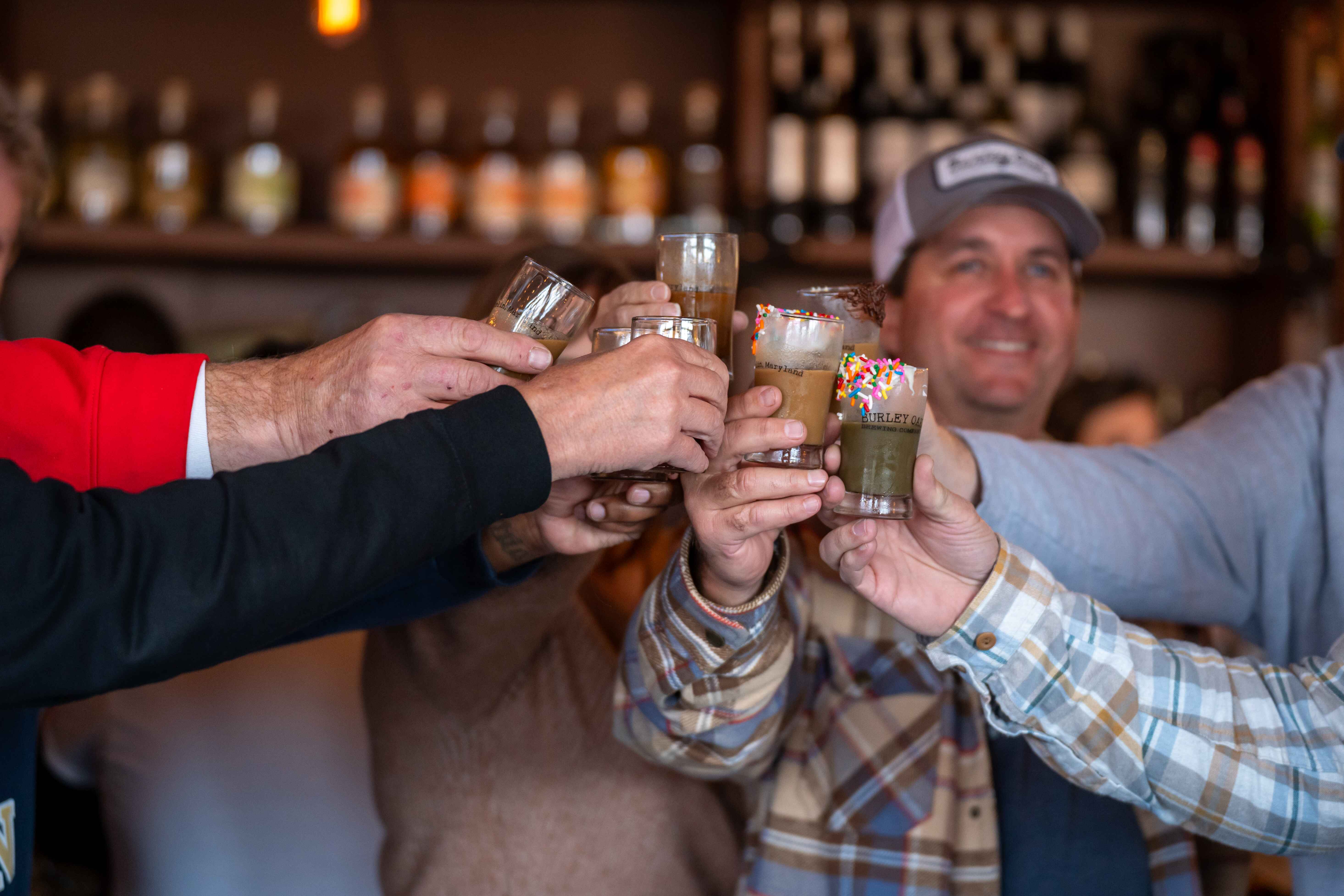 a group of men toasting at a bar