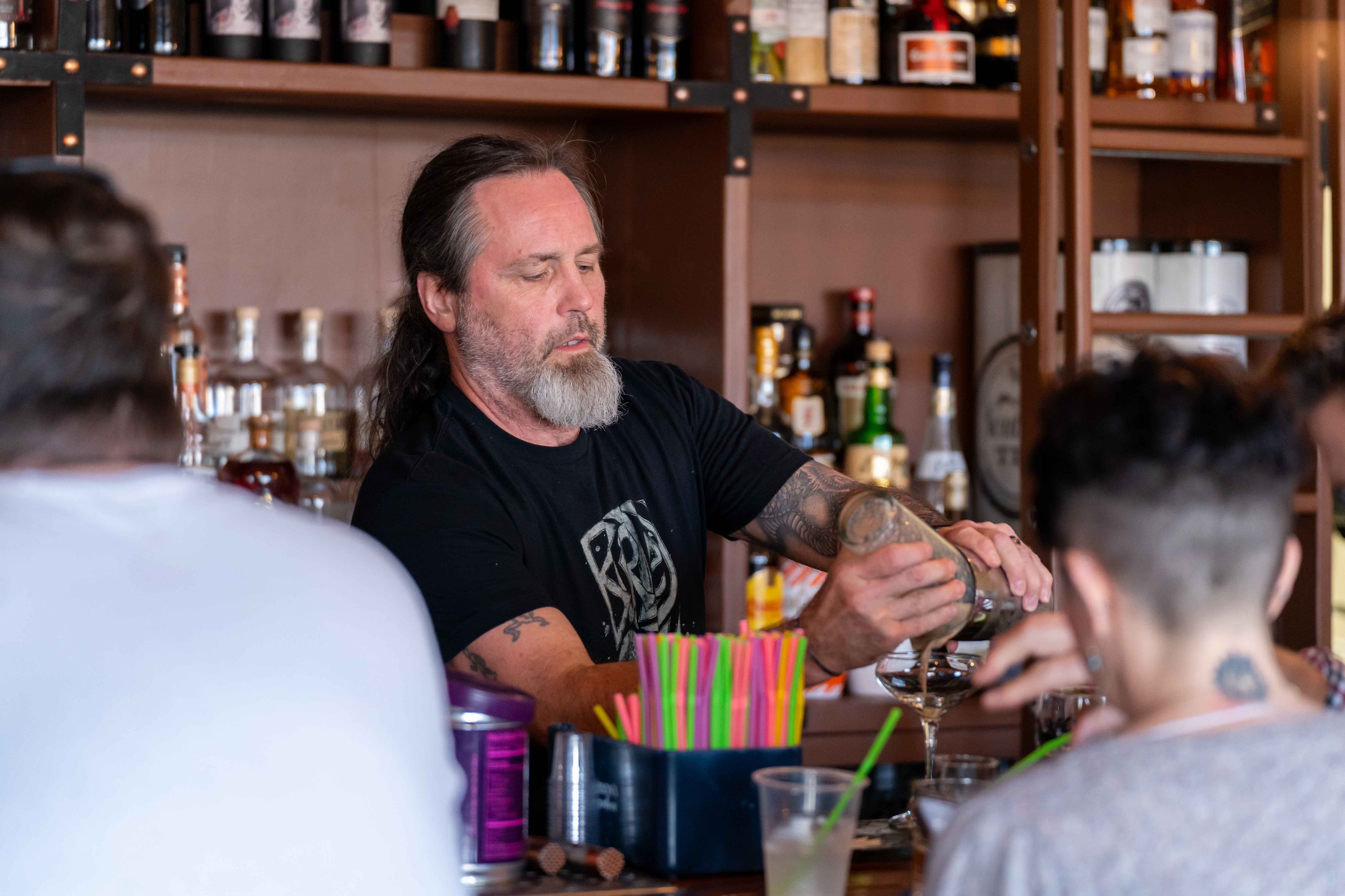 a man pouring a drink at a bar