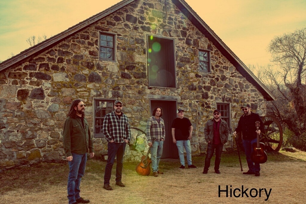 a group of men standing in front of a stone building