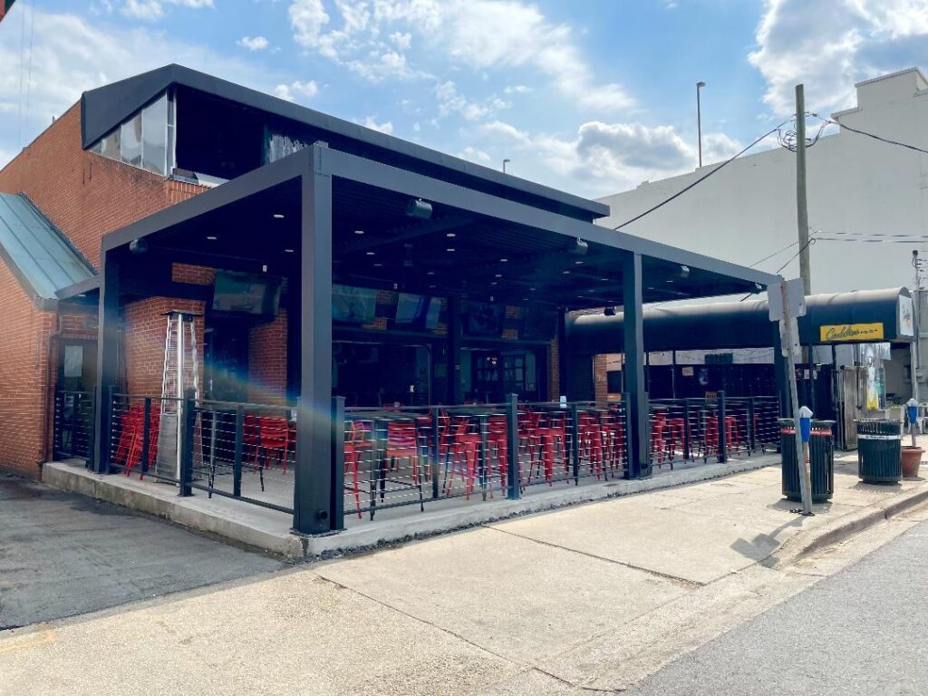 a restaurant with red chairs and an umbrella