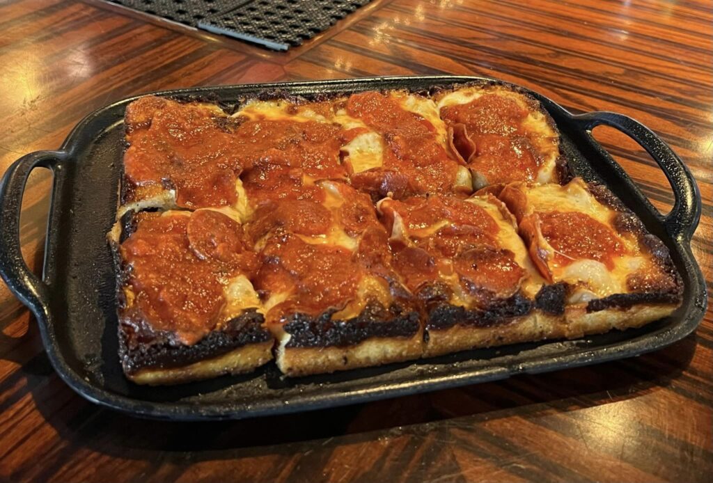a square pizza sitting on top of a metal pan