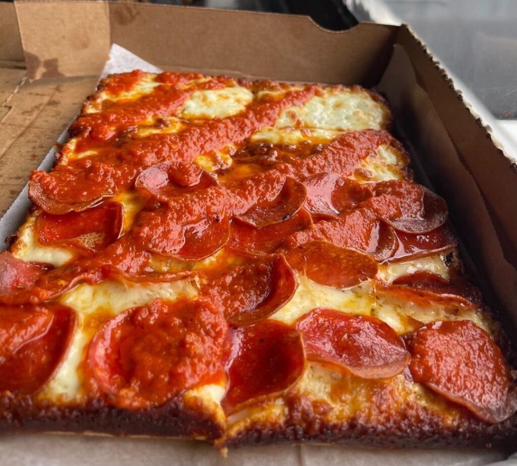 a pepperoni pizza sitting in a box on top of a table