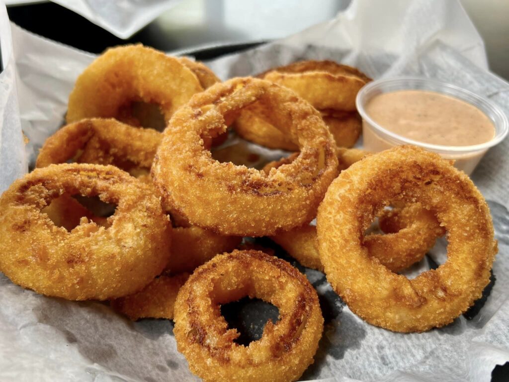 a bunch of doughnuts on a plate with dipping sauce
