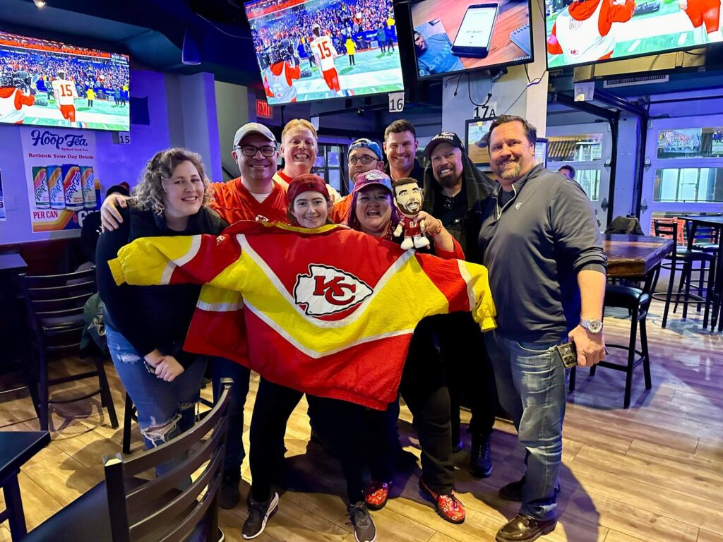 a group of people holding up a jersey