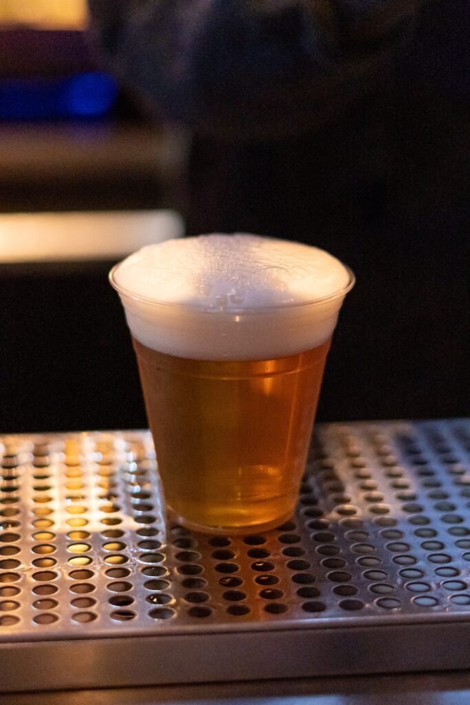 a glass of beer sitting on top of a table