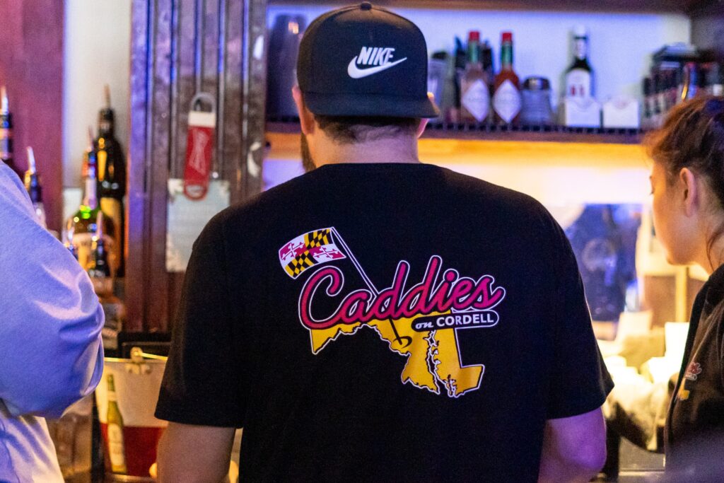 a man and woman standing in front of a bar