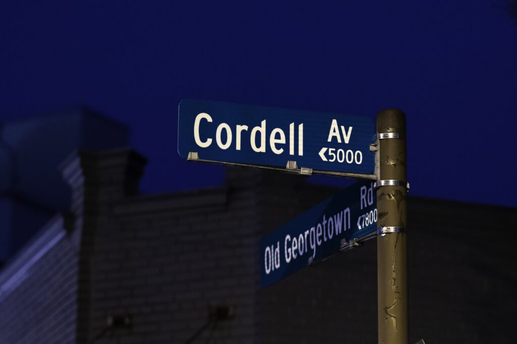 two street signs on a pole in front of a building