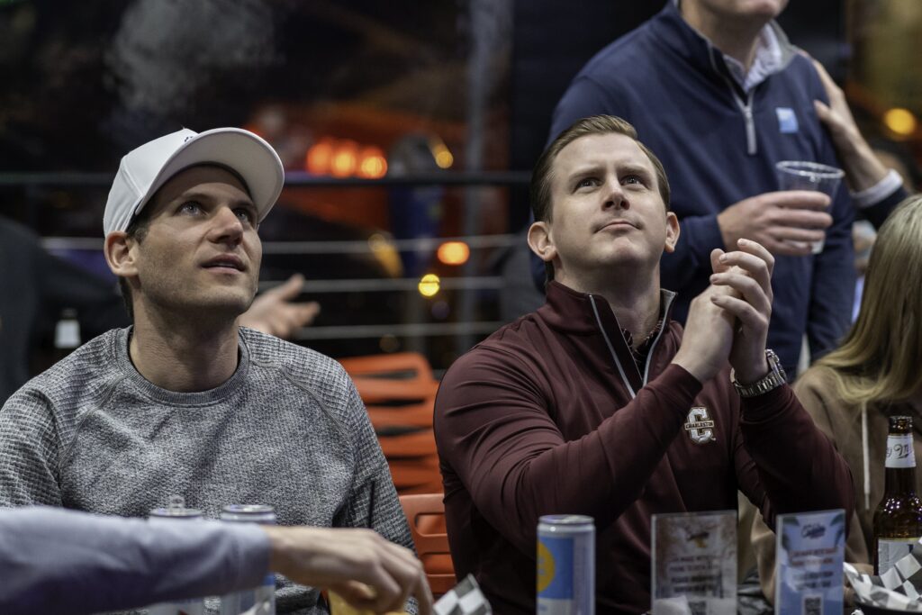 two men sitting at a table with drinks