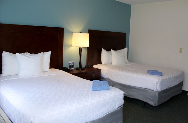 Two beds made with white bed sheets