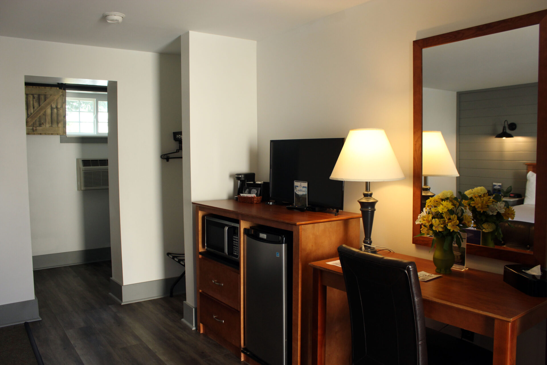 Work desk next to tv, mini fridge, and microwave