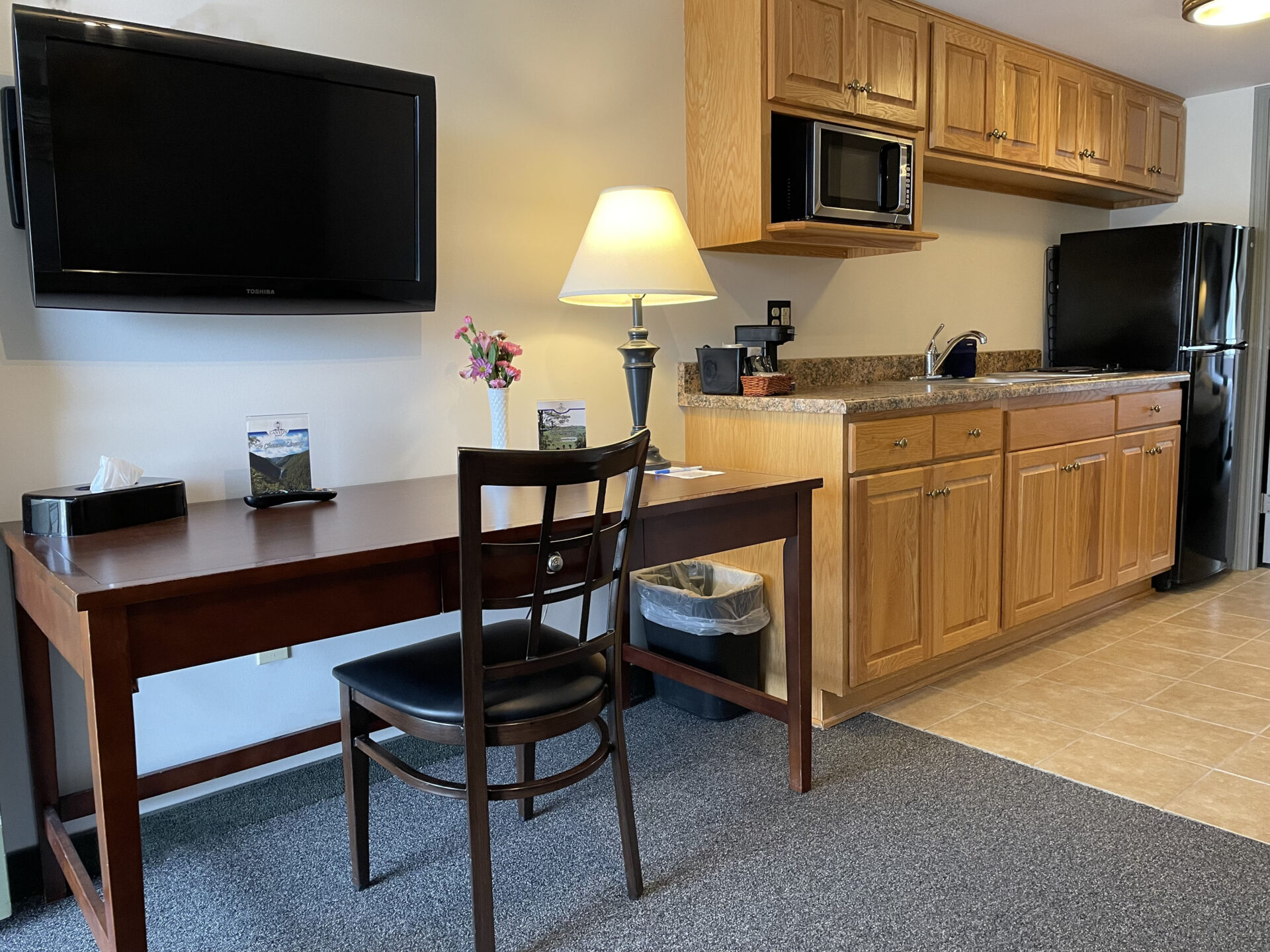Wooden work desk and television next to kitchen