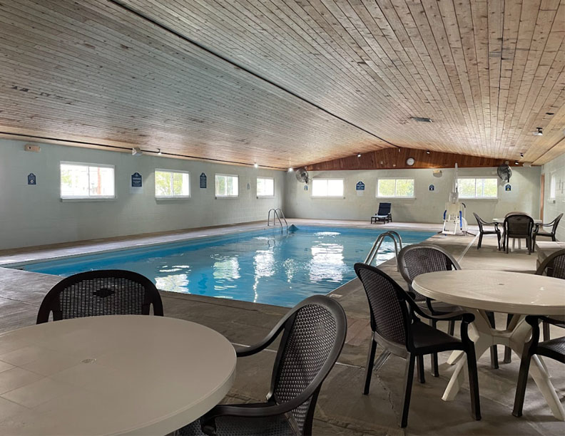 Indoor pool with round tables surrounding it