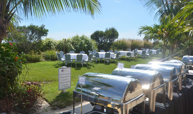 a row of silver portable toilets sitting on top of a lush green field