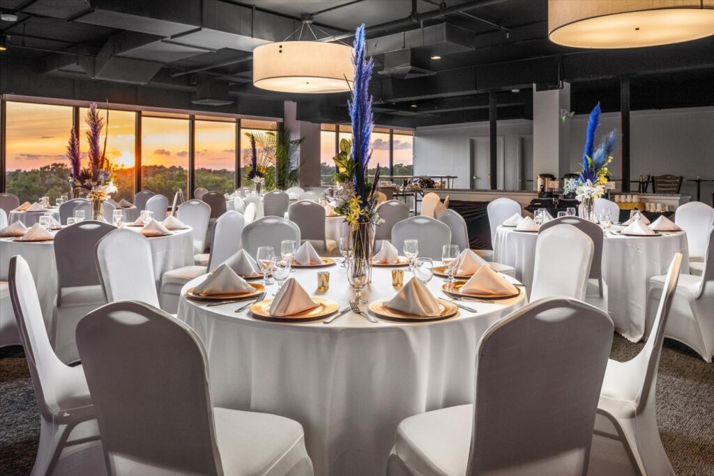 a room filled with white tables and chairs