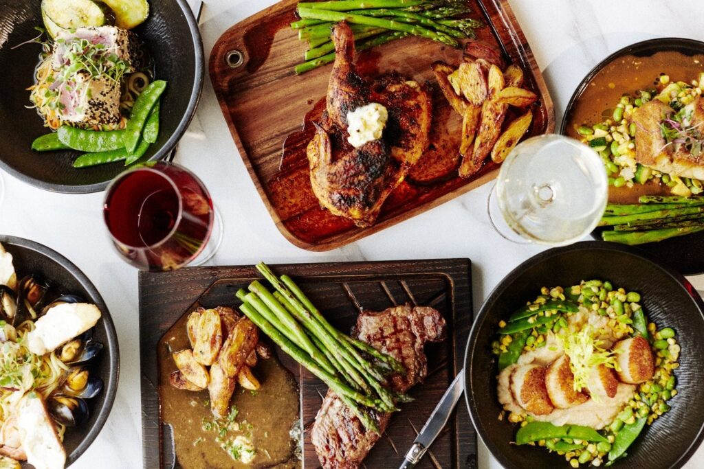 a table topped with plates of food and glasses of wine