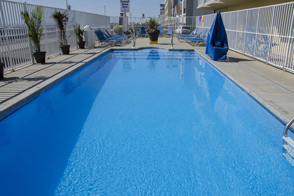 an empty swimming pool with chairs and umbrellas