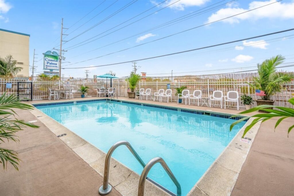 an empty swimming pool with chairs and umbrellas