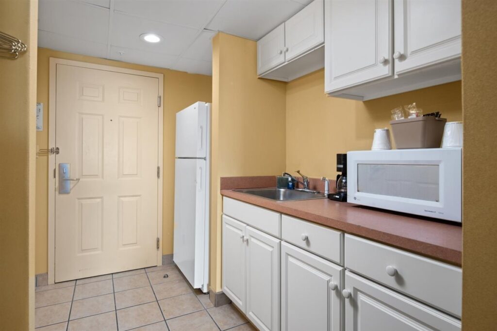 a kitchen with white cabinets and yellow walls