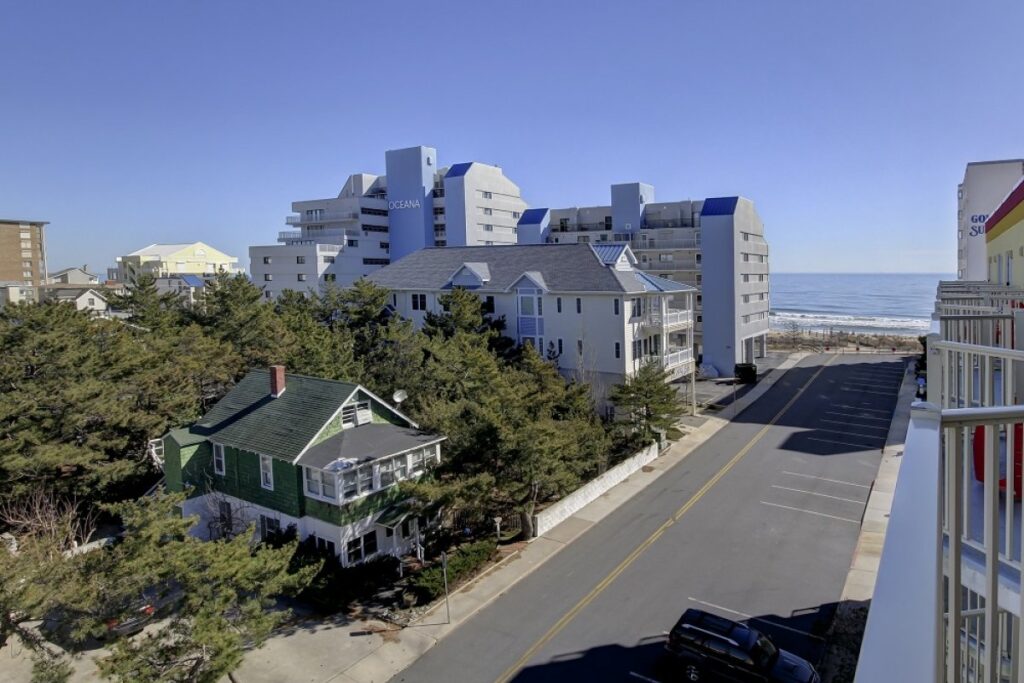 a street with houses on the side and ocean in the background