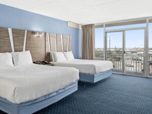 a hotel room with two beds and a balcony
