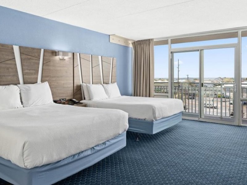 a hotel room with two beds and a balcony