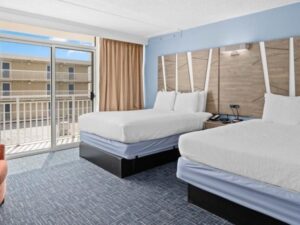 a hotel room with two beds and a balcony