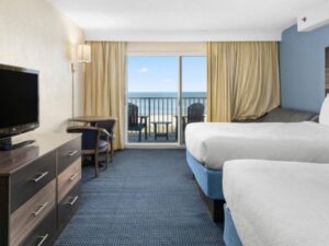 a hotel room with two beds and a flat screen tv