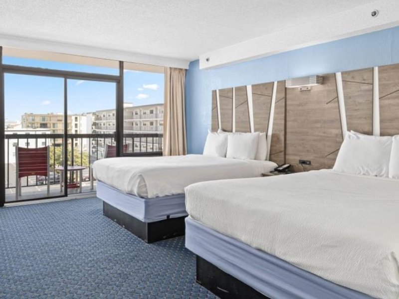 a hotel room with two beds and a balcony