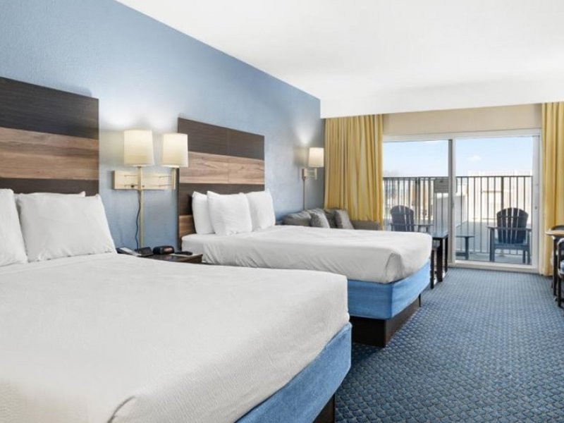 a hotel room with two beds and a balcony