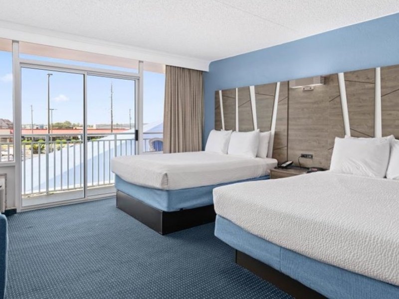 a hotel room with two beds and a balcony