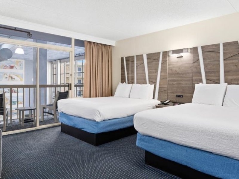 a hotel room with two beds and a balcony