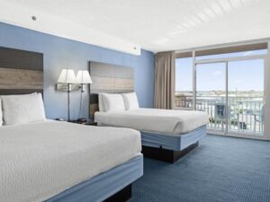 a hotel room with two beds and a balcony