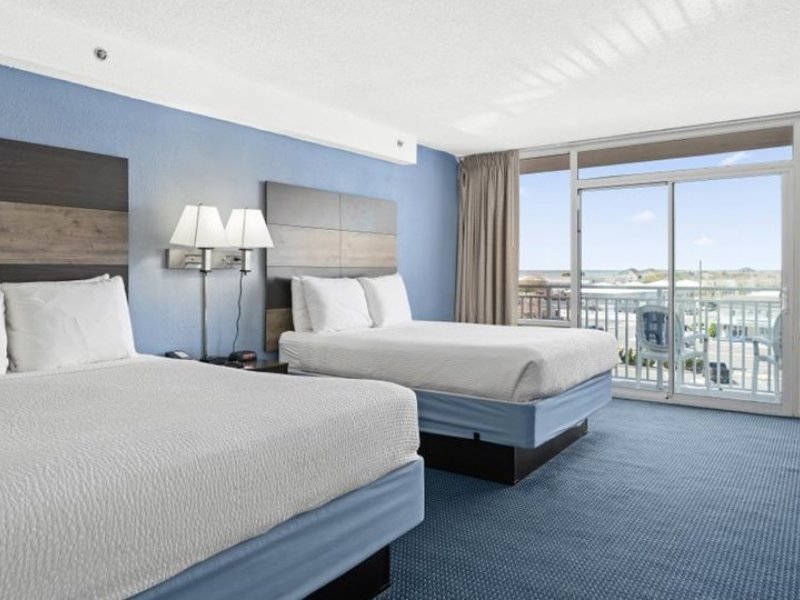 a hotel room with two beds and a balcony