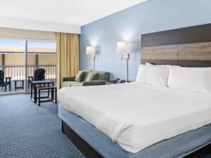 a hotel room with a king bed and balcony view