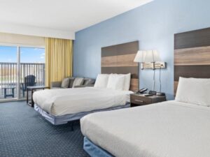 a hotel room with two beds and a balcony