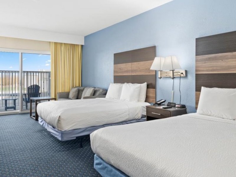 a hotel room with two beds and a balcony
