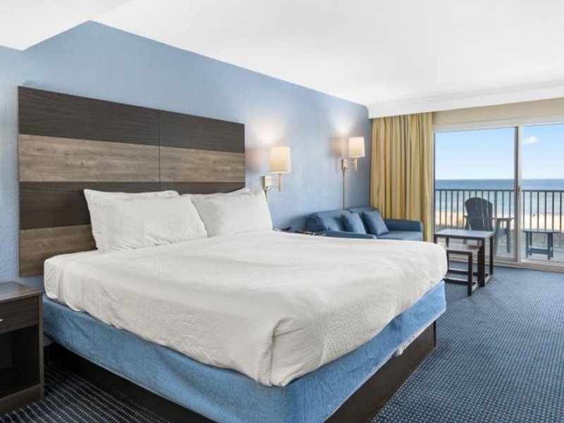a hotel room with a large bed and ocean view