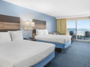 a hotel room with two beds and a balcony