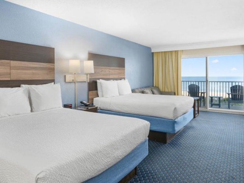 a hotel room with two beds and a balcony
