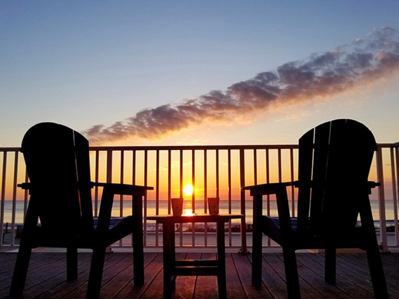 two chairs sitting on top of a wooden deck