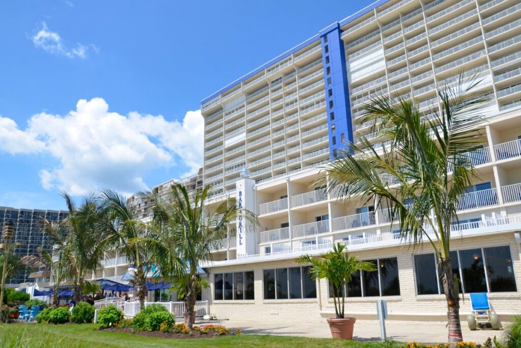 a large hotel with palm trees in front of it