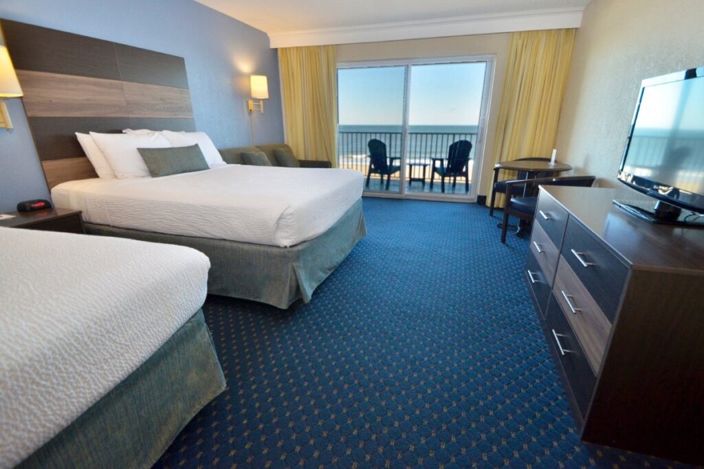 a hotel room with two beds and a flat screen tv