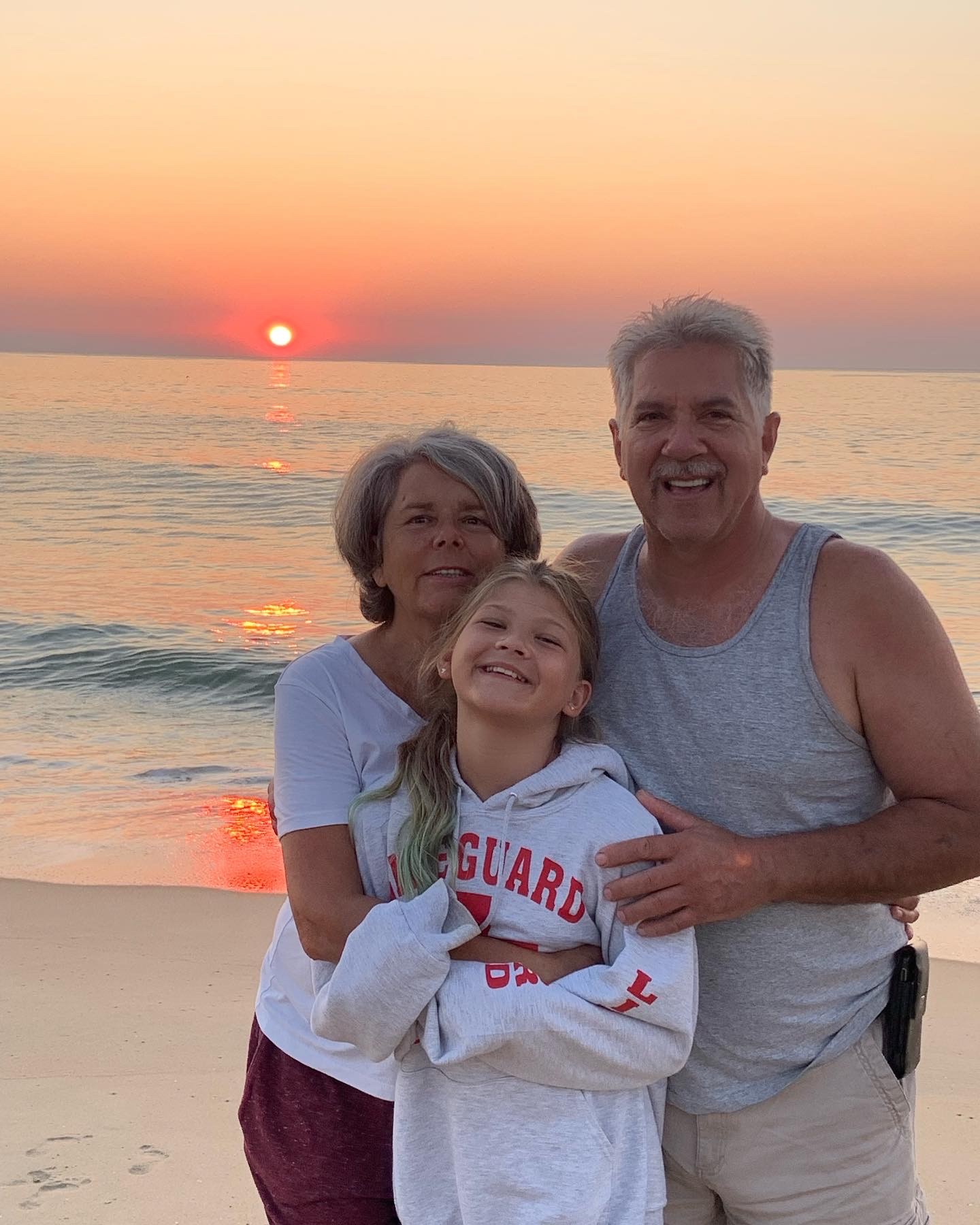 an older man and two young girls on the beach