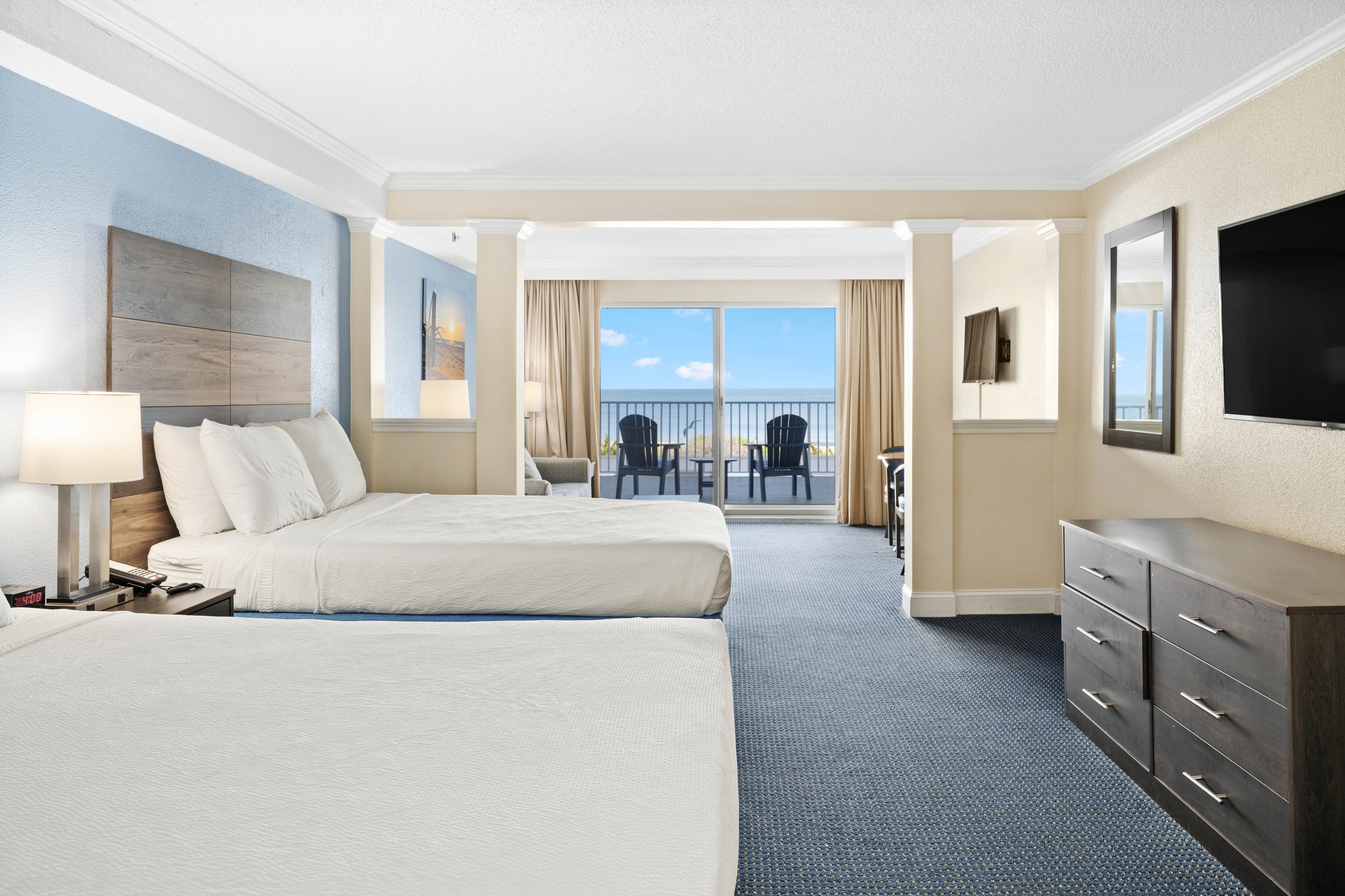 a hotel room with two beds and a flat screen tv