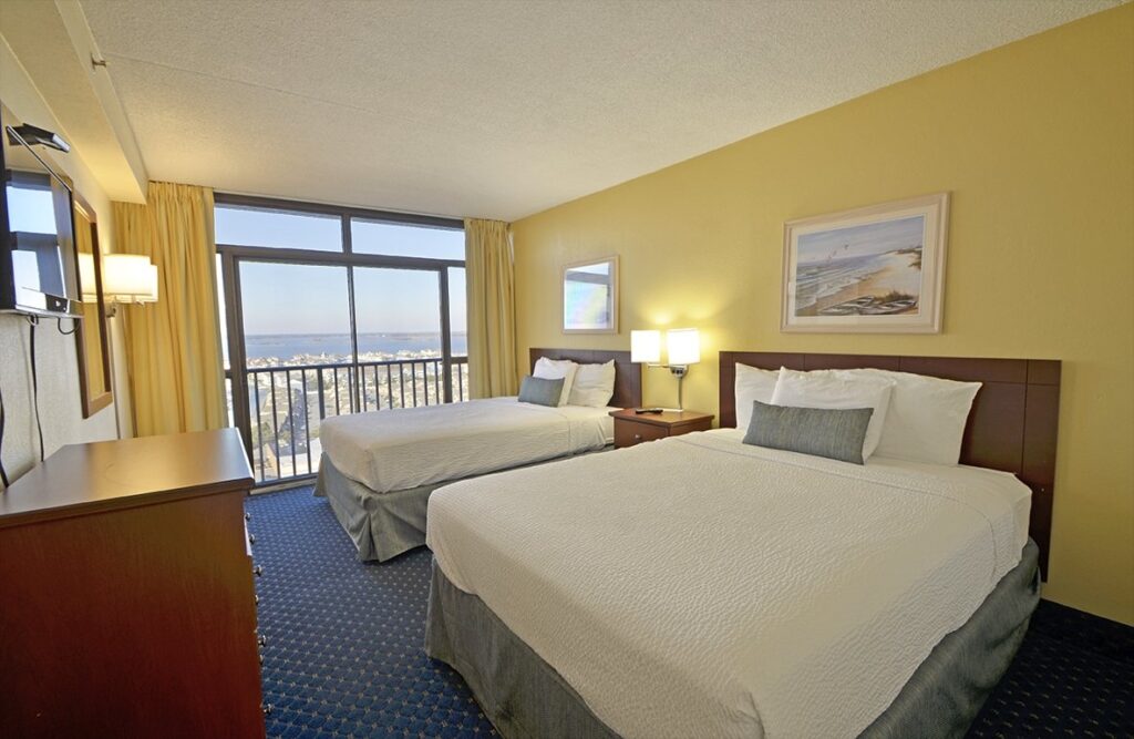 a hotel room with two beds and a balcony