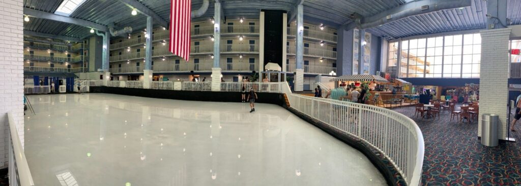 an indoor ice rink with people skating on it