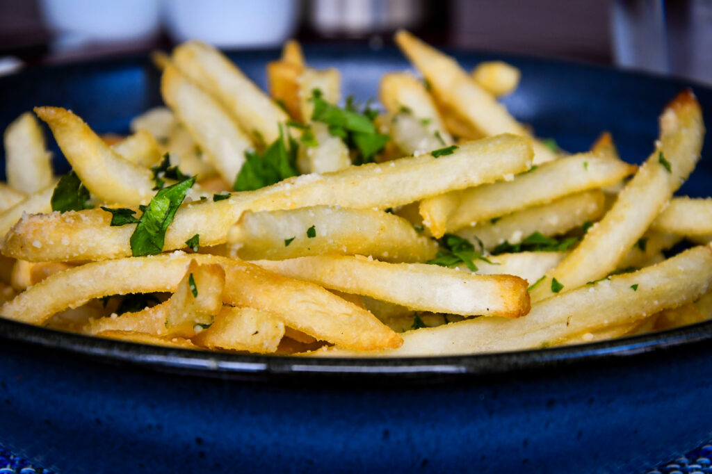 a plate of french fries with parsley on top