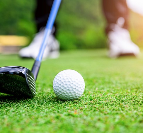 a golf ball and club on the green grass