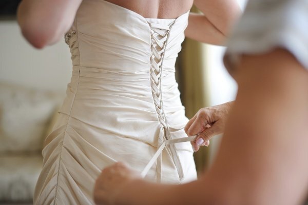The bride putting on her wedding dress.